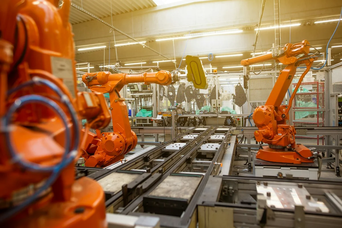 Industrial robotic arms operating along an automated factory production line